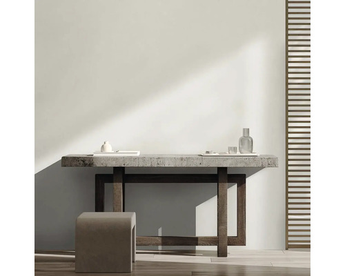 Svetlá miestnosť s minimalistickým dizajnom, ktorá sa skladá zo stola, stolice a dekoračných predmetov.