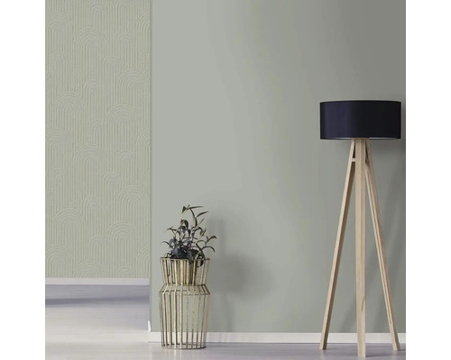 Obývacia izba so vzorovanou tapetou, črepníkovou rastlinou a stojacou lampou