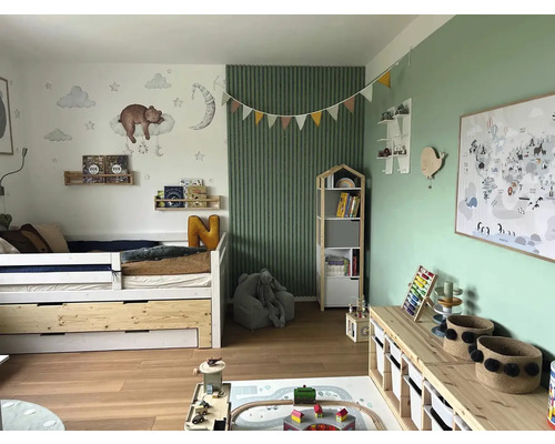 Svetlá detská izba s posteľou, knižnicou, hračkami a nástennou dekoráciou