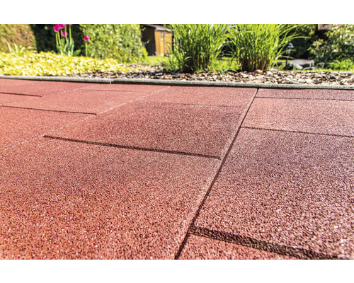 Detail červených gumových terasových dosiek v záhrade.