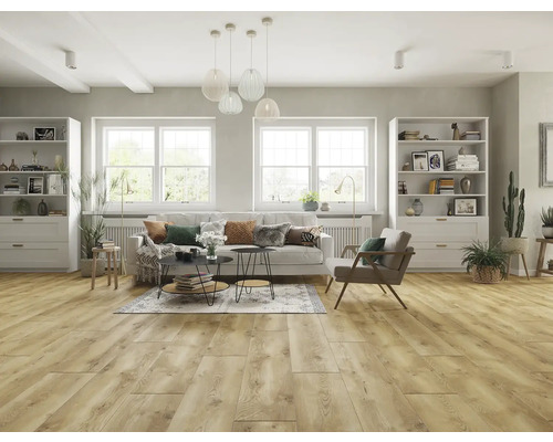 Svetlá obývacia izba s drevenou podlahou, pohovkou, kreslami, regálmi a dekoratívnymi prvkami.