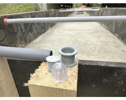 Detailný záber odtokových armatúr a rúrok pre stavbu jazierka