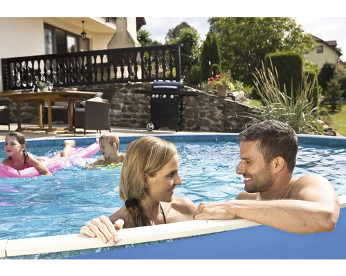 Rodina relaxuje v nadzemnom bazéne v záhrade s grilom a záhradným nábytkom