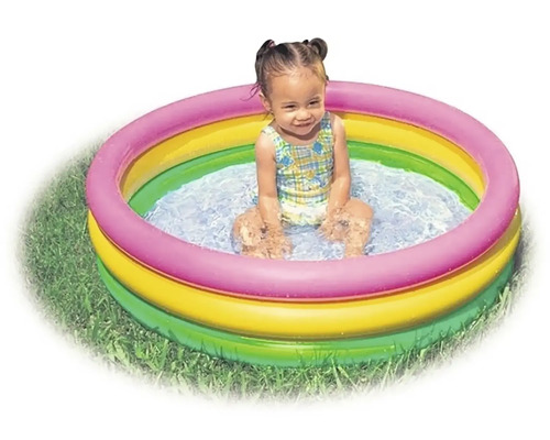 Dieťa sedí v nafukovacom bazéniku na záhrade.