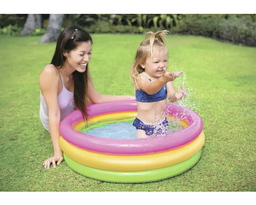 Matka a dieťa sa hrajú v detskom bazéne v záhrade.