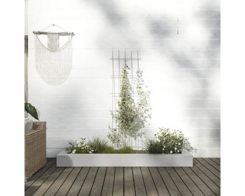 Scéna s kvetináčom, mrežou na popínanie a nástennou dekoráciou vo vonkajšom priestore.