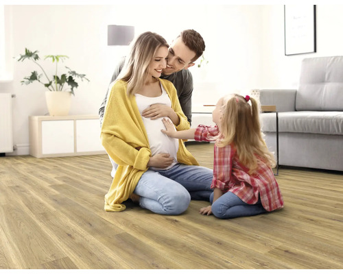Rodina s dieťaťom na svetlej drevenej podlahe v obývacej izbe.