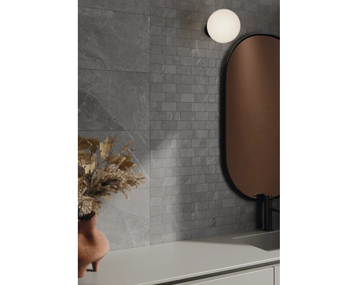 Kúpeľňa so sivými obkladmi, zrkadlom a lampou