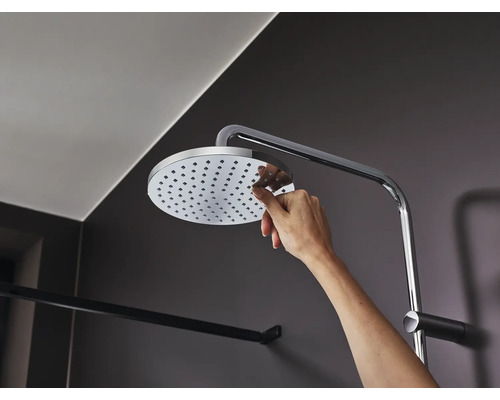 Ruka sa dotýka sprchovej hlavice so sprchovým ramenom v kúpeľni