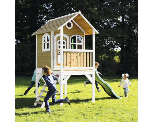 Drevený domček na hranie so šmýkačkou a hrajúcimi sa deťmi v záhrade