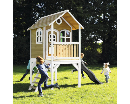 Drevený hrací domček so šmýkačkou a rebríkom v záhrade, hrajú sa deti