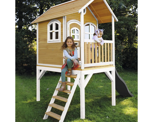 Drevený hrací domček so rebríkom a šmýkačkou v záhrade