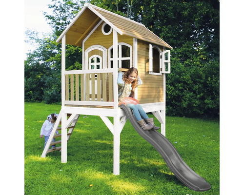 Drevený hrací domček so šmýkačkou a dvoma hrajúcimi sa deťmi v záhrade.