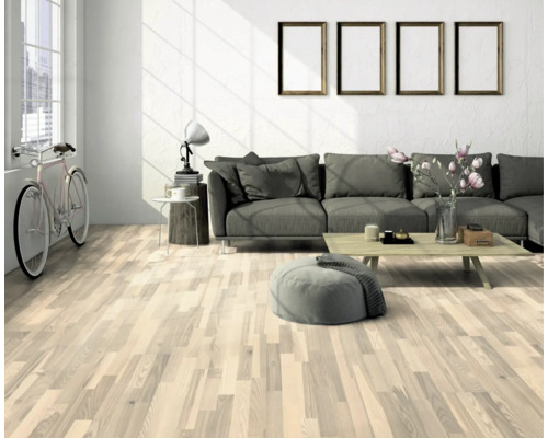 Svetlá obývacia izba s drevenou podlahou, pohovkou a dekoratívnymi prvkami pre útulnú atmosféru.