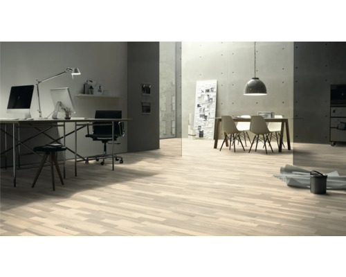 Svetlá miestnosť s drevenou podlahou, písacím stolom a jedálenským stolom.