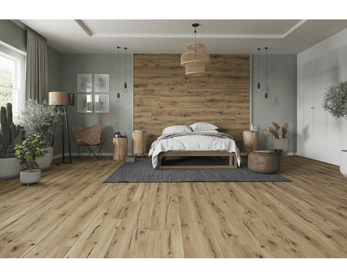 Svetlá spálňa s drevenou podlahou, posteľou, dekoráciou a prírodnými prvkami pre priateľskú atmosféru.