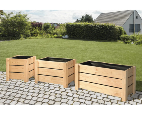 Tri drevené kvetináče v záhrade.