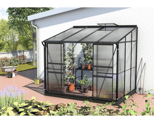 Skleník z kovu a plastu s rastlinami v záhrade