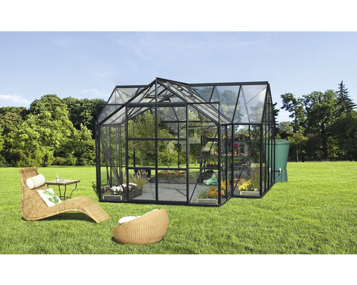 Skleník s rastlinami, nábytkom a nádržou na vodu v záhrade