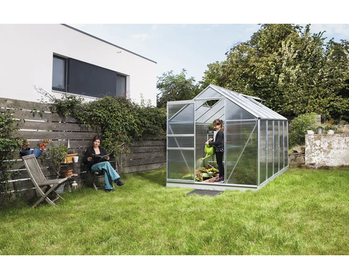 Záhradná scéna so skleníkom, žena a dieťa pri záhradničení