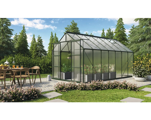 Skleník v záhrade s jedálenským stolom a stoličkami na terase