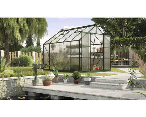 Skleník v záhrade s rastlinami a záhradnými doplnkami.