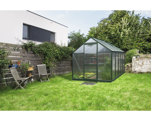 Skleník v záhrade s trávnikom a dreveným plotom