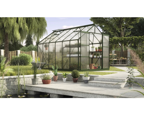 Skleník v záhrade s rastlinami a záhradným náradím