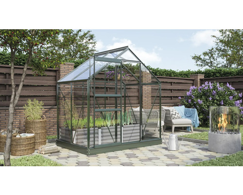 Skleník v záhrade s rastlinami a záhradnou dekoráciou