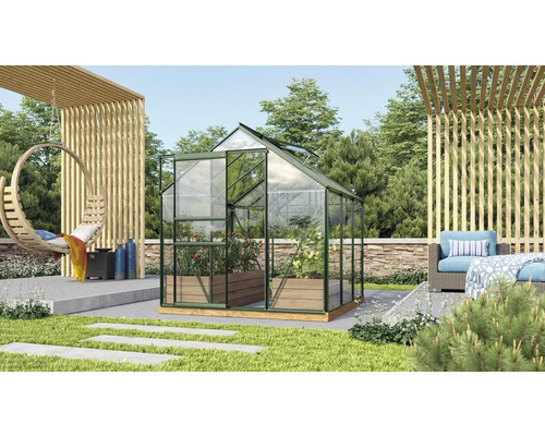 Skleník v záhrade s rastlinami a záhradnou dekoráciou