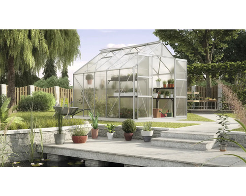 Skleník v záhrade s rastlinami a jazierkom