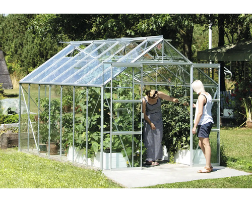 Skleník s rastlinami a dvoma ľuďmi v záhrade