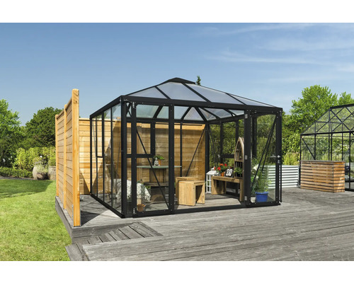 Skleník so sklenenými stenami a dreveným interiérom v záhrade.