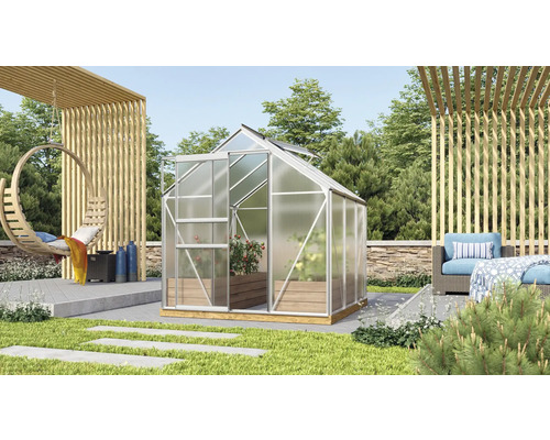 Skleník s hliníkovým rámom a rastlinami v záhrade.