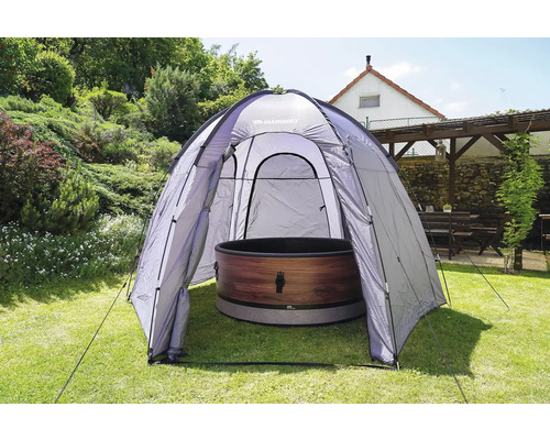 Vonkajšia scéna s kúpacou kaďou pod kupolovitým stanom v záhrade.