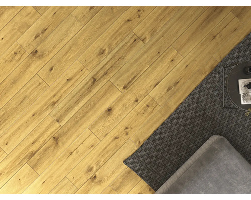 Položená laminátová podlaha s kobercom, gaučom a stolom