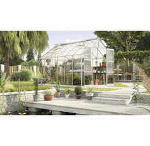 Skleník v záhrade s rastlinami a záhradným náradím