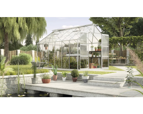 Skleník v záhrade s rastlinami a záhradným náradím