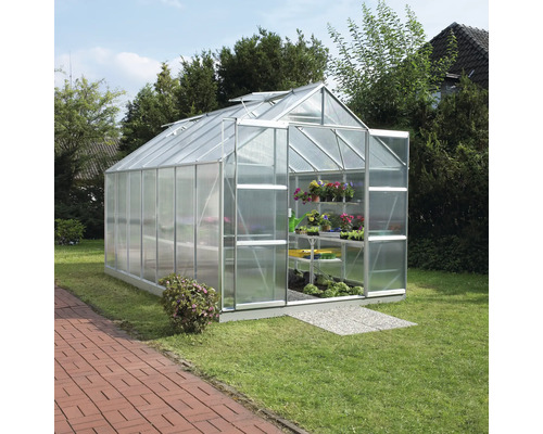 Skleník v záhrade s regálmi na rastliny