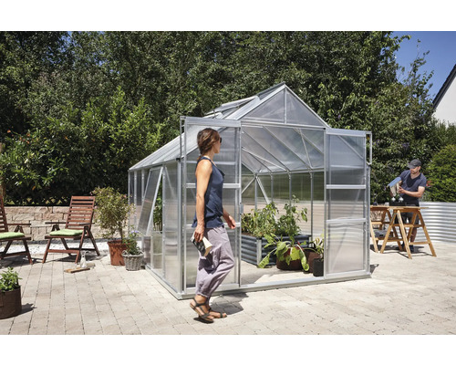 Skleník s rastlinami a ľuďmi v záhrade