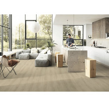 Svetlá, otvorená obývacia izba s drevenou podlahou, sivou sedačkou a kuchynským ostrovčekom