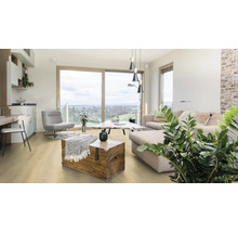 Svetlá obývacia izba s pohovkou, kreslom, drevenou truhlou a drevenou podlahou