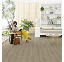 Obývacia izba s drevenou podlahou a ženou sediacou na stoličke