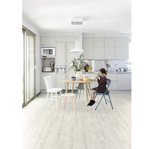 Svetlá kuchyňa s jedálenským stolom, stoličkami a dievčaťom, ktoré je.