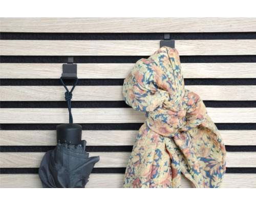 Nástenný panel s háčikmi, na ktorých visí dáždnik a šál