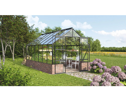 Skleník s tehlovou stenou a sklenenými stenami v záhrade