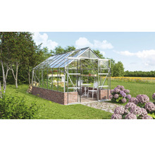 Skleník s policami, stolom a stoličkami v záhrade