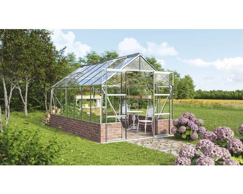 Skleník s policami, stolom a stoličkami v záhrade