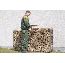 Muž vkladá drevo do regálu na drevo