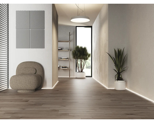 Svetlý interiér s akustickými panelmi, kreslom a hrnkovými rastlinami na drevenej podlahe.